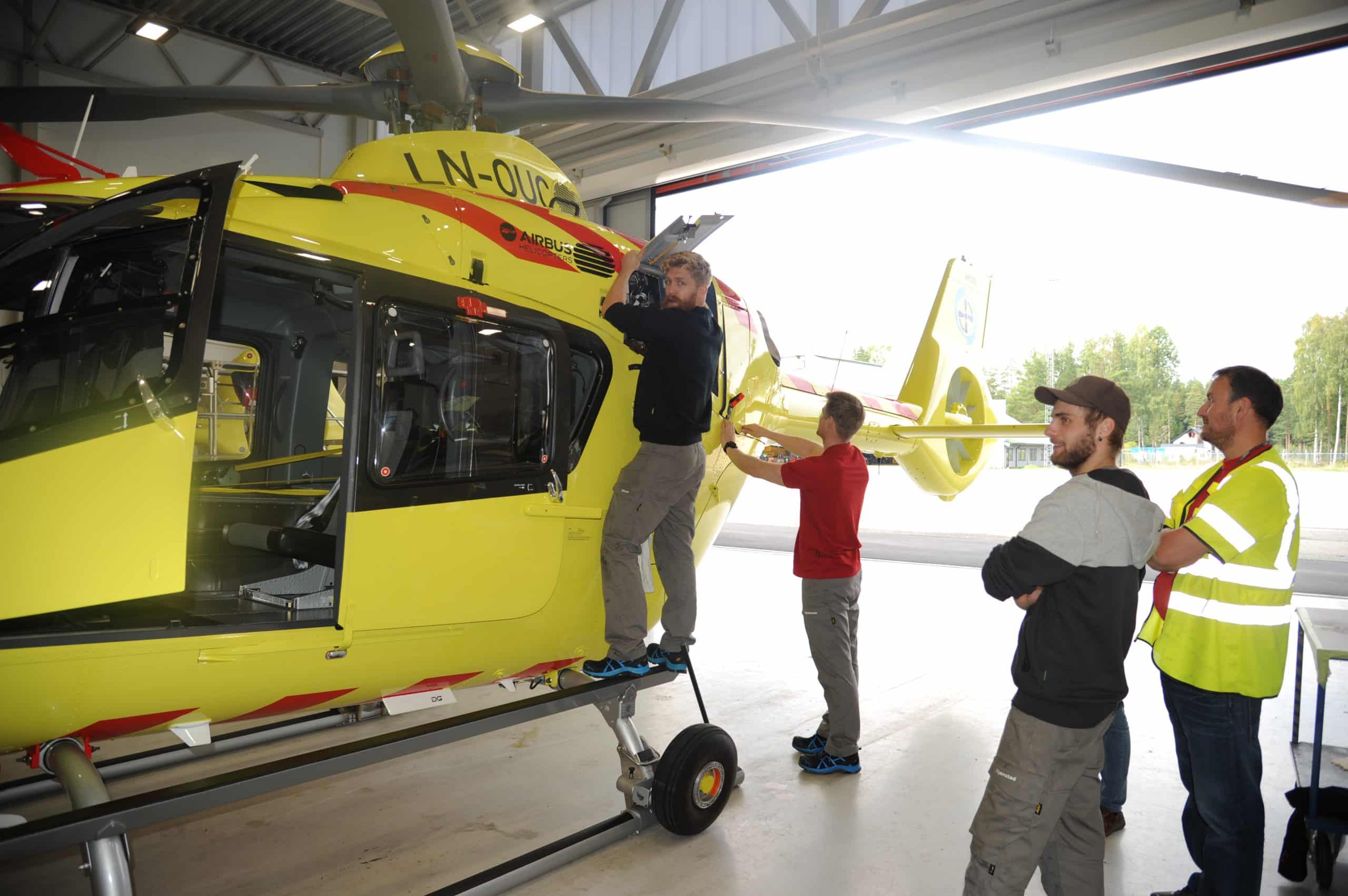 Personer undersøker legehelikopter