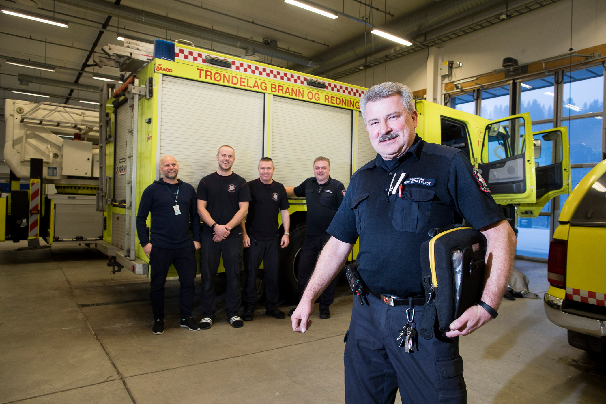 Ivar Stenstvedt står sammen med kollegaen foran brannbilen