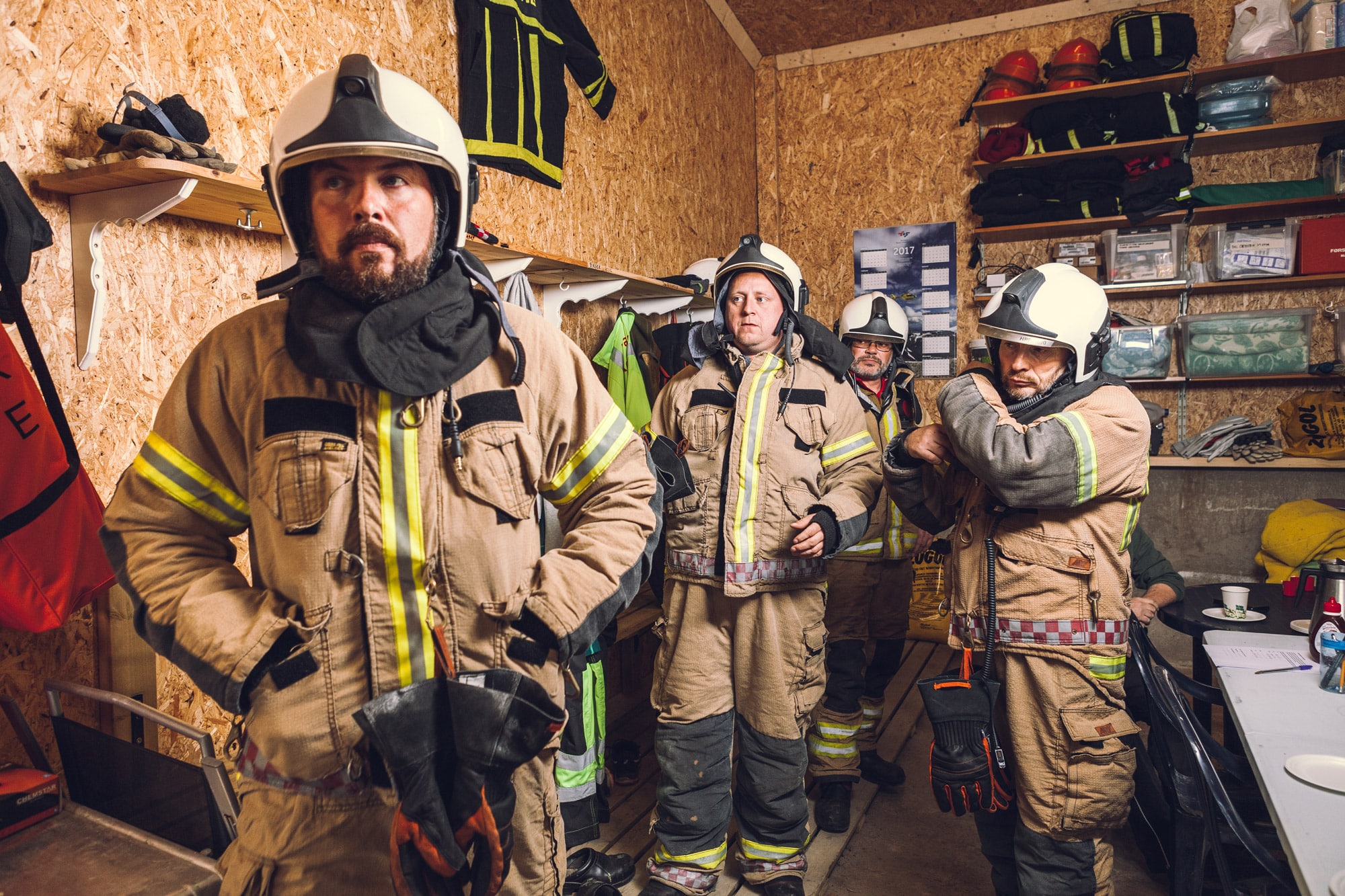 Fire brannmenn i uniform gjør seg klare til å rykke ut som akutthjelpere.