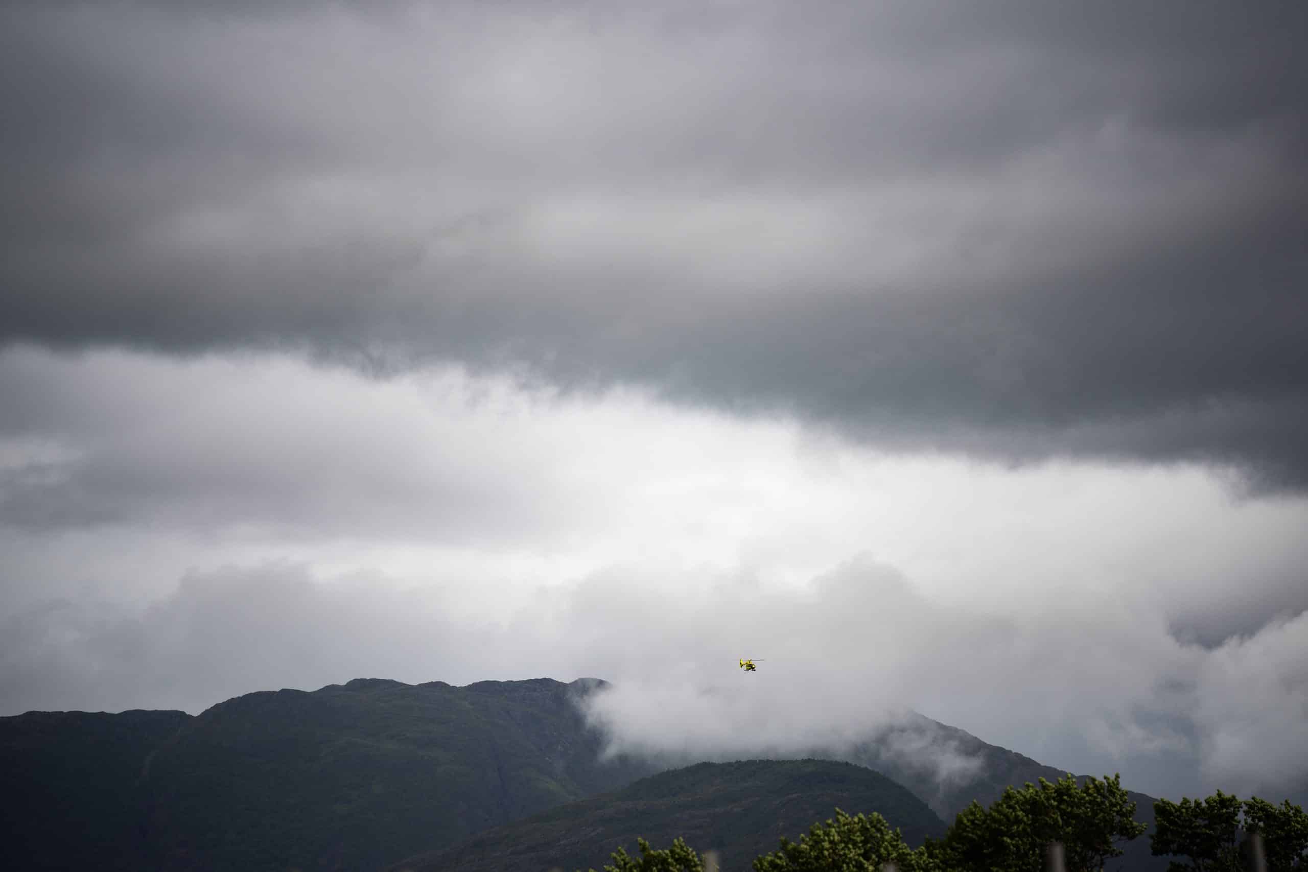 helikopter flyr over fjellet med tåke