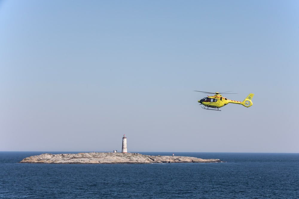 Helikopter flyr over en holme i nærheten av Arendal