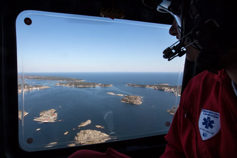 Utsikt fra helikoptervindu når et helikopter flyr over kysten ved Arendal