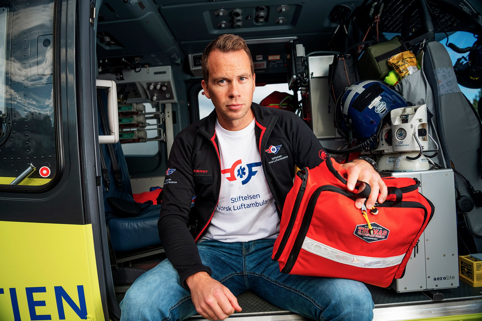 Stipendiat Jostein Rødseth Brede sitter i helikopterdøra med rescue bag.