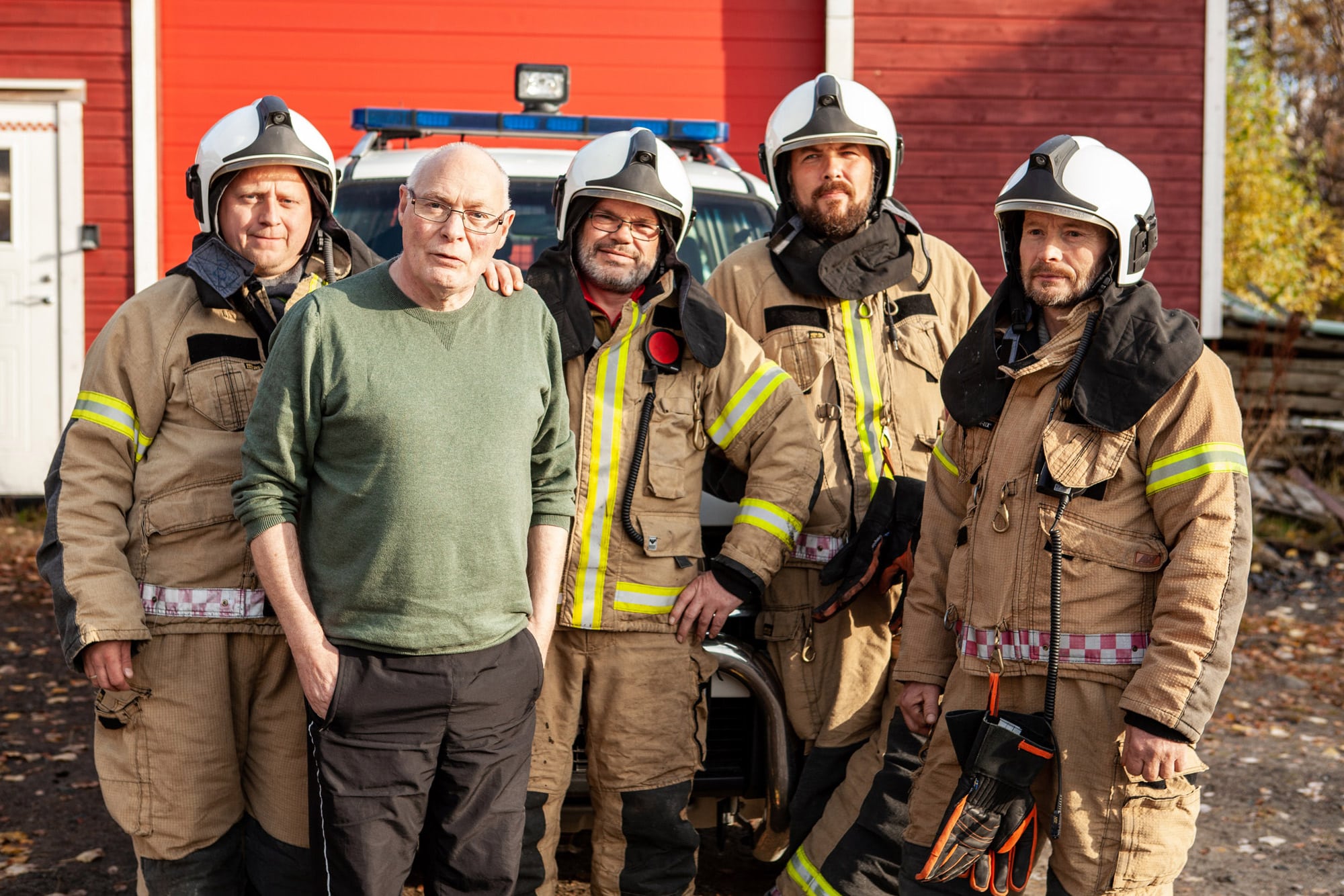 Kåre, som fikk hjertestans, står sammen med fire akutthjelpere kledd i brannmannuniform.