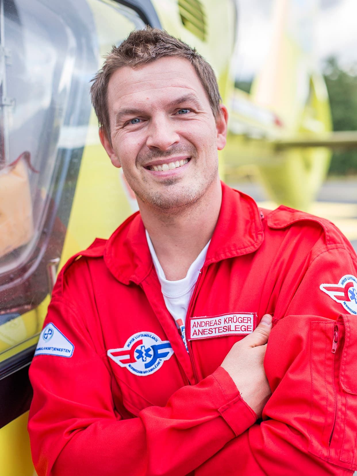 Portrettbilde av anestesilege Andreas Krüger foran et legehelikopter.