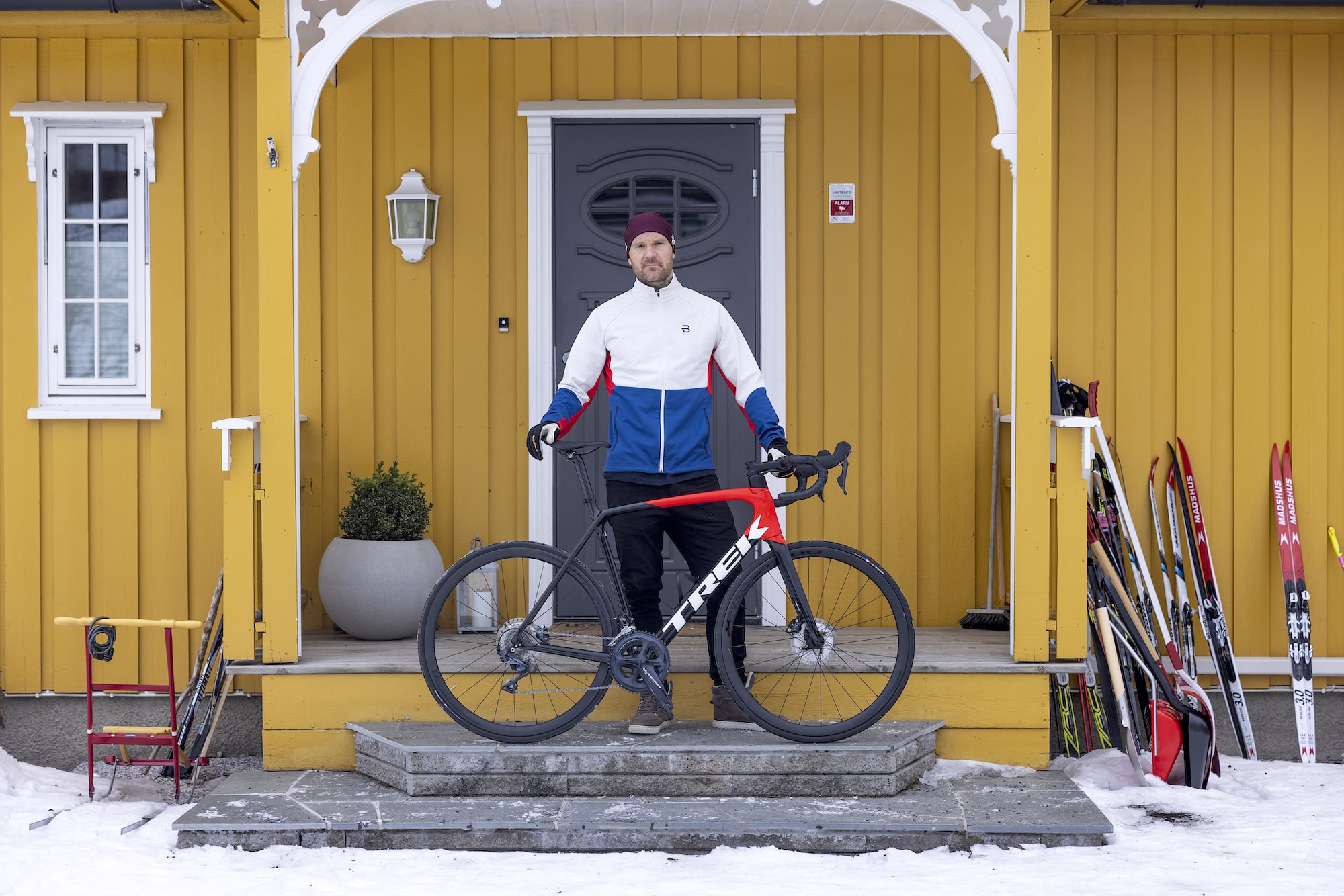 Øystein Pettersen står med sykkelen foran huset sitt 