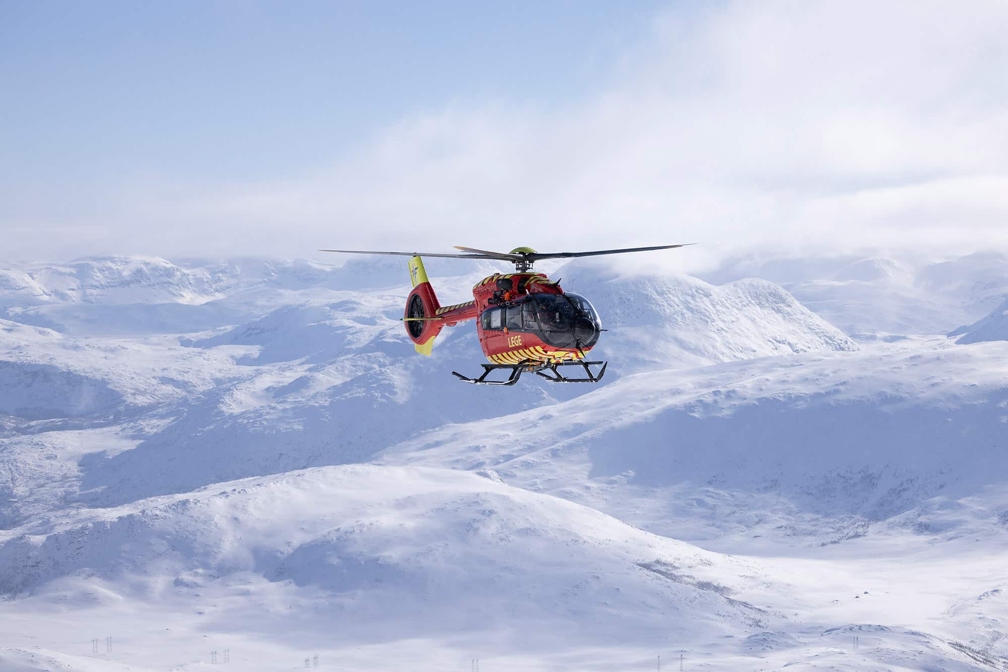 Utviklingshelikopteret flyr over snødekt fjellandskap
