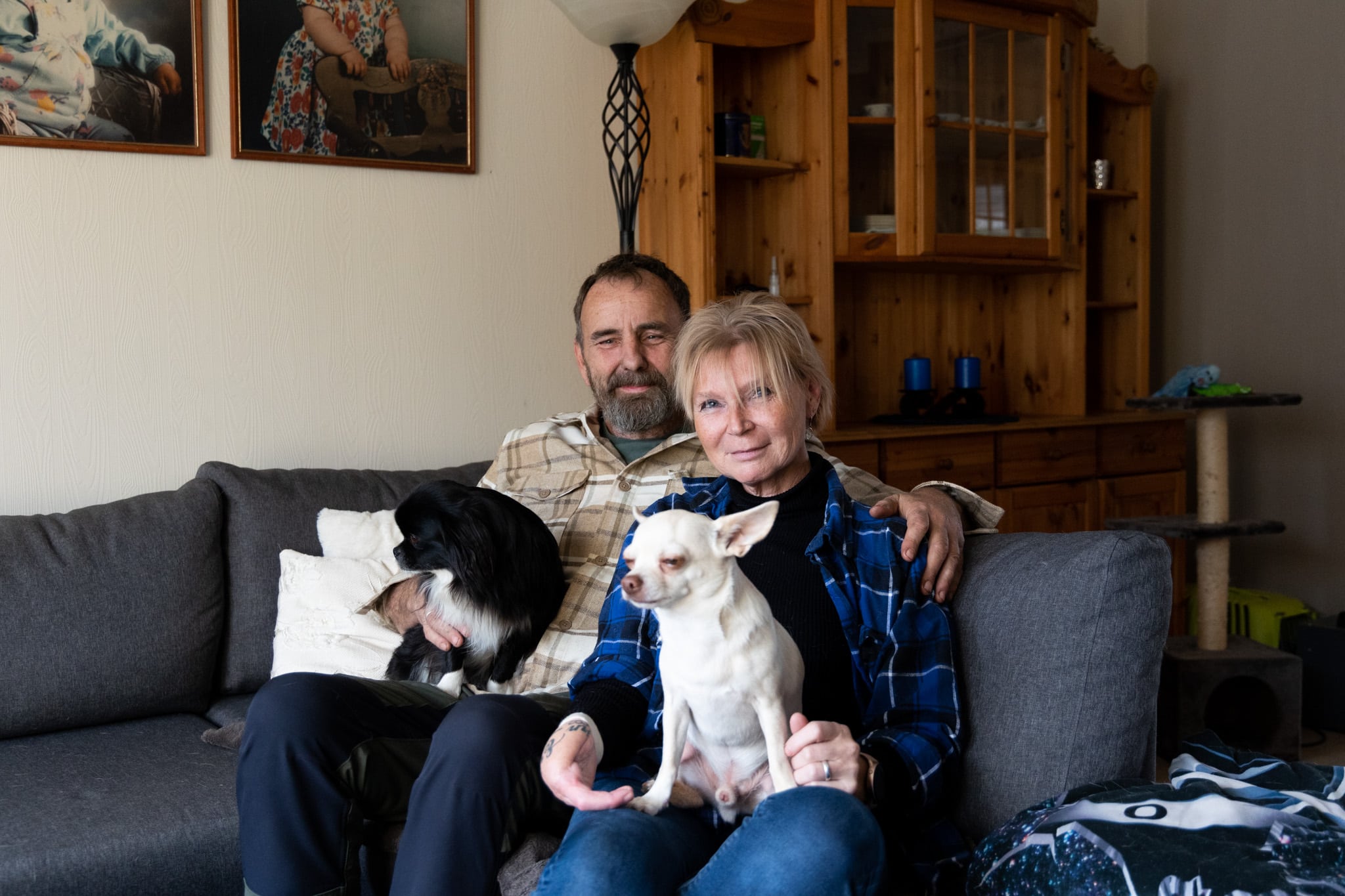 Janne-Helen med mannen sin, Bjørn-Erik og deres to hunder i sofaen