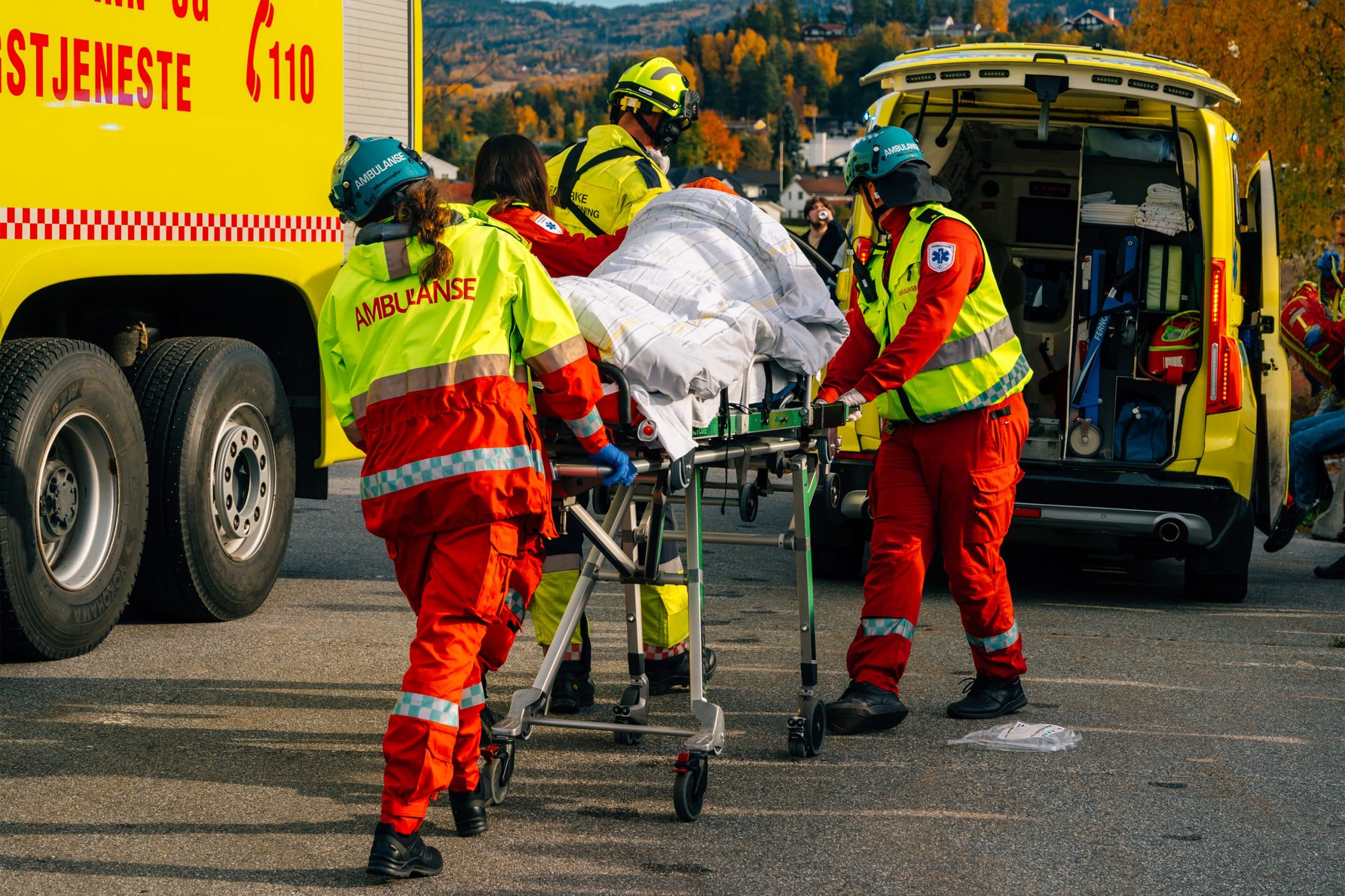 Ambulansearbeidere frakter pasient til ambulanse under TAS 25-markering i Hønefoss.