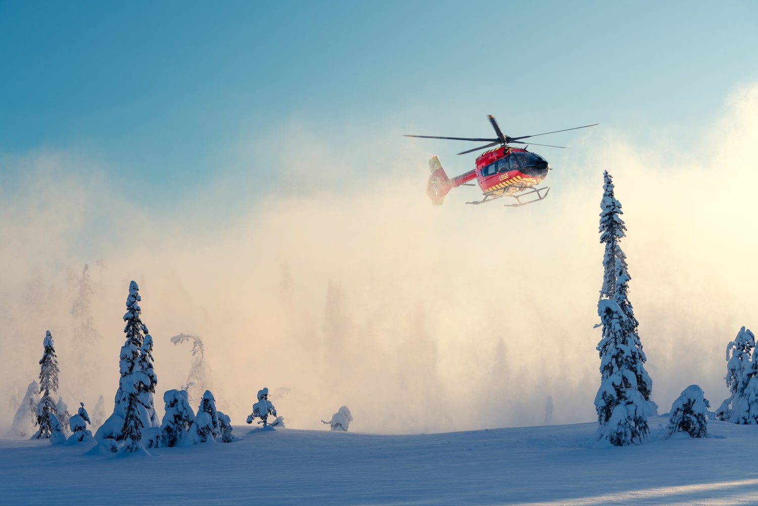 Helikopter flyr i et vinterlandskap