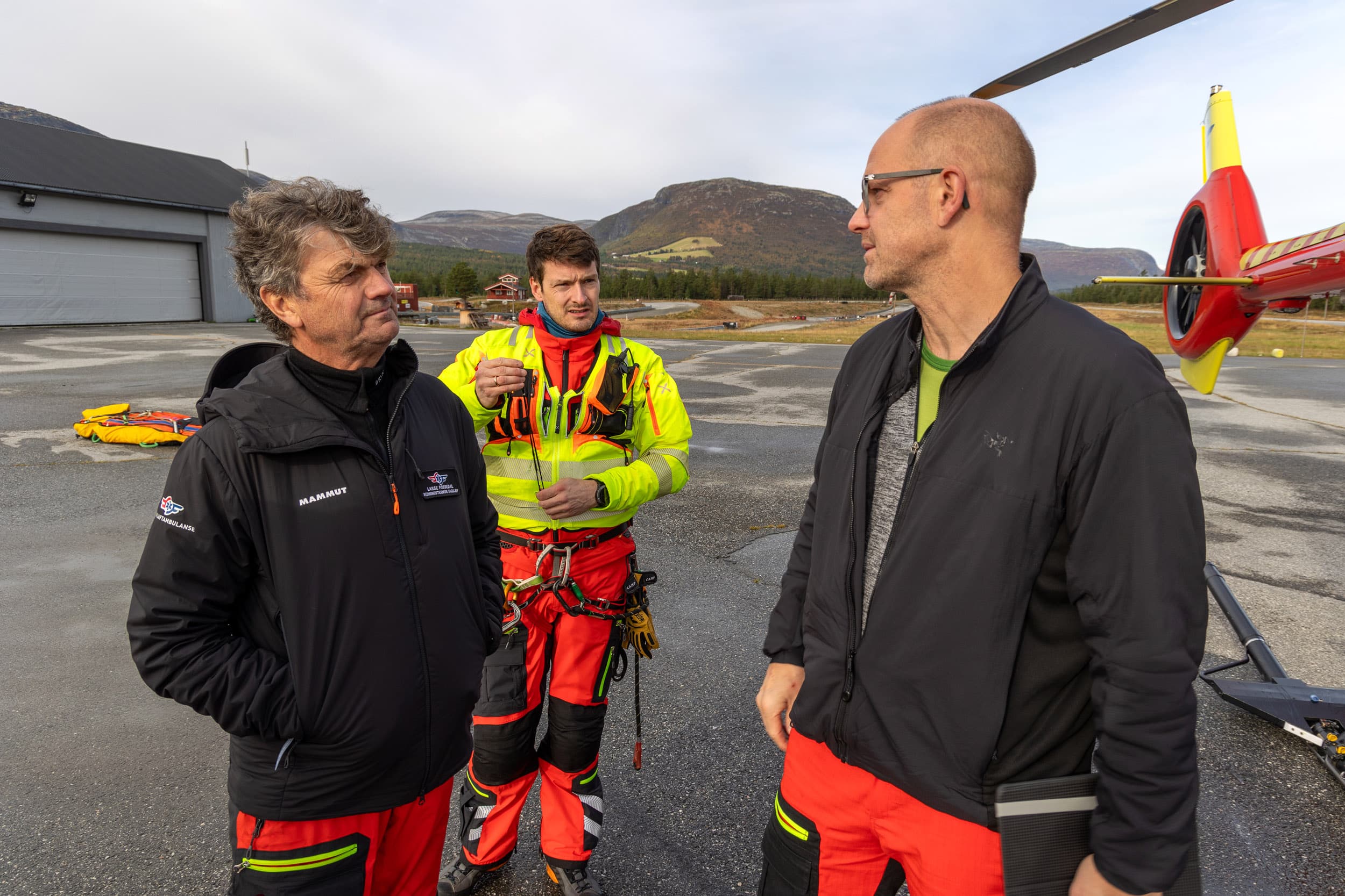 En fot i bakken: Lasse Fossedal (f.v.), Oddbjørn Tranvåg og Erik Normann utveksler erfaringer mellom flyturene hvor de trener på heis i helikopter. 