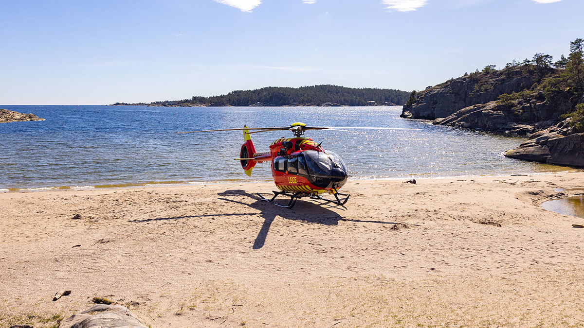 Utviklingshelikopteret står i strandsonen en solfylt dag