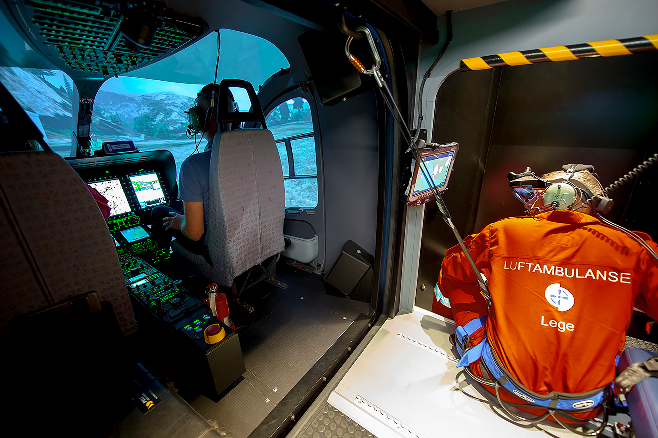 Bilde av personell fra legehelikopteret som trener på å fly helikopter i simulator. Simulatortrening gir crewet mulighet til å øve på uventede situasjoner