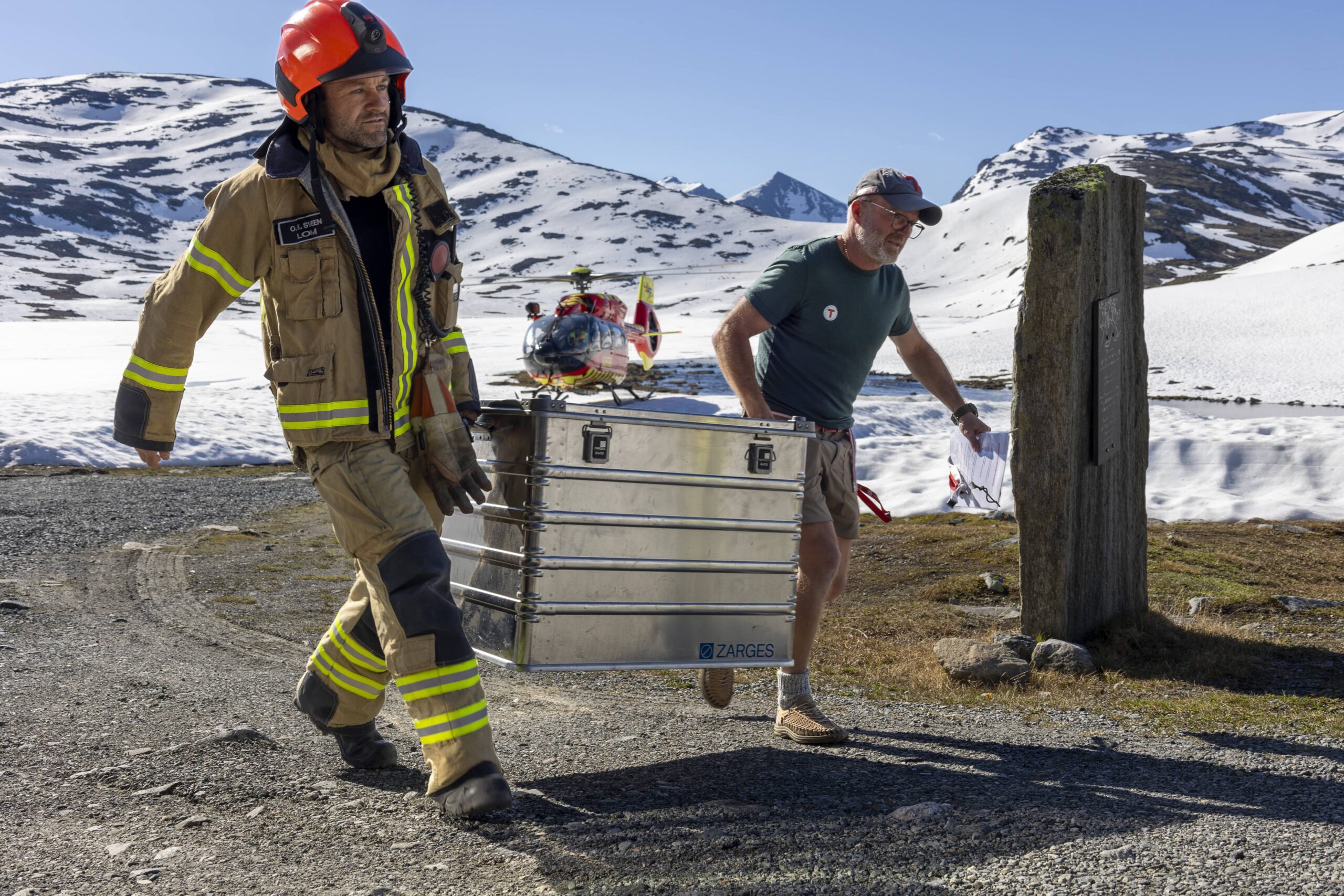 Sammen mot brannen: Ole Kristian Sveen fra Lom ble fløyet inn til brannen på Leirvassbu og frakter her utstyr mot turisthytta med DNTs Terje Sølna.