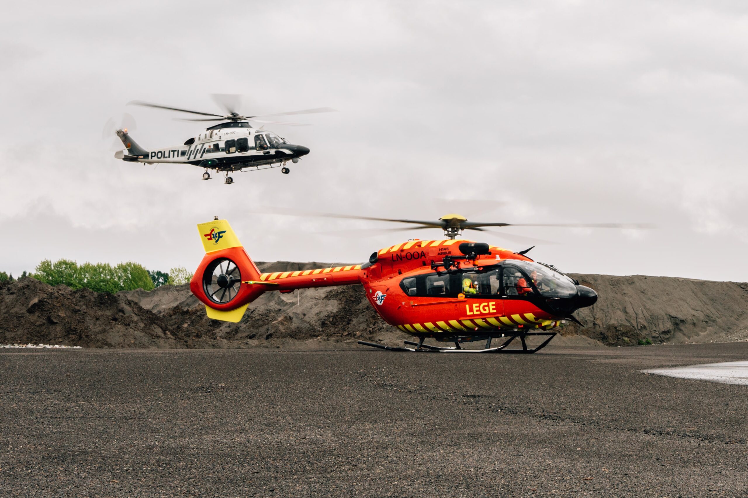 Politihelikopteret og Stiftelsen Norsk Luftambulanses utviklingshelikopter ankom Haug samtidig, tett etterfulgt av et gult legehelikopter.