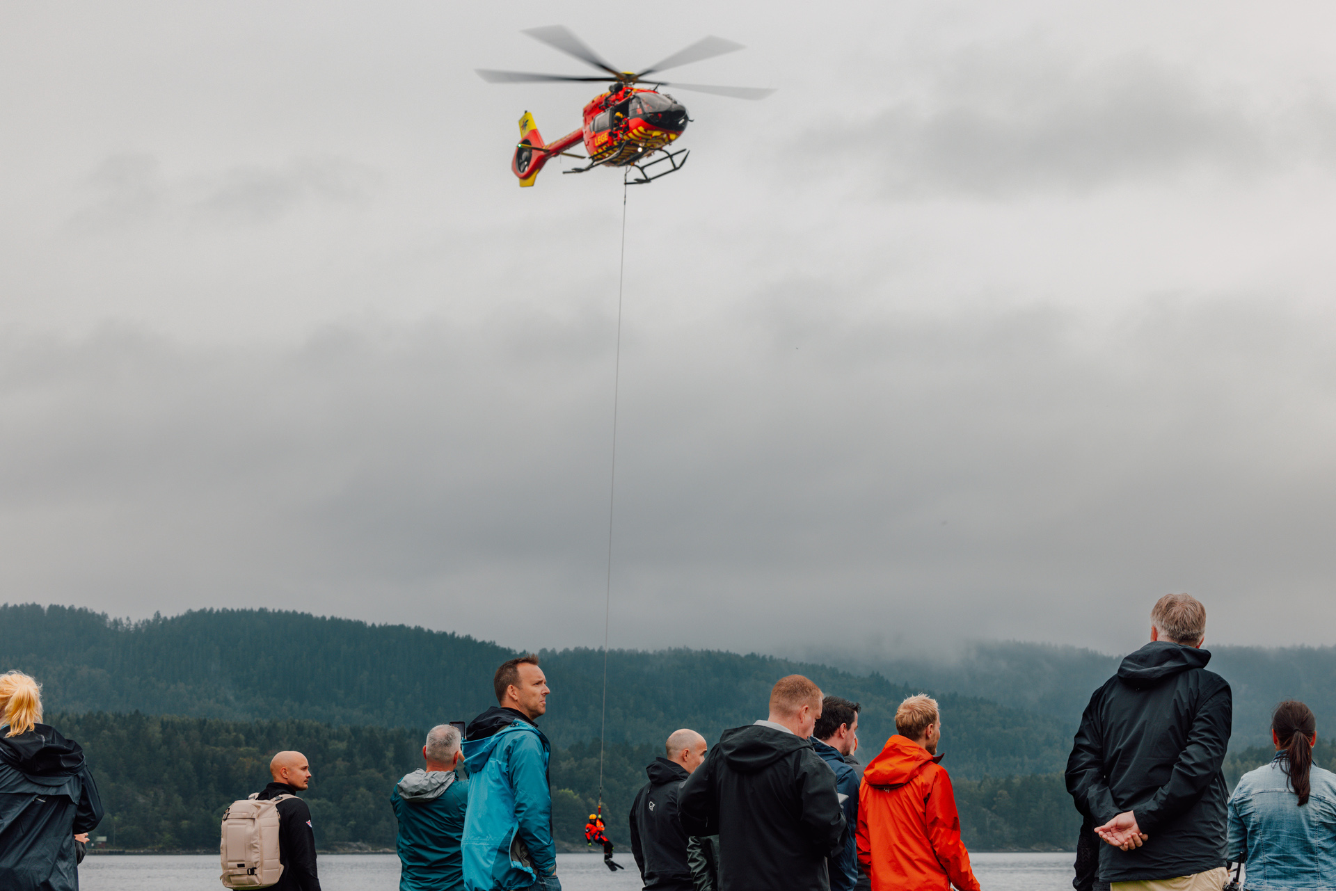 Stiftelsen Norsk Luftambulanses utviklingshelikopter med en underhengende redningsmann. Bildet er tatt i forbindelse med en øvelse for luftambulansekoordinatorene ved LA AMK på Oscarsborg.