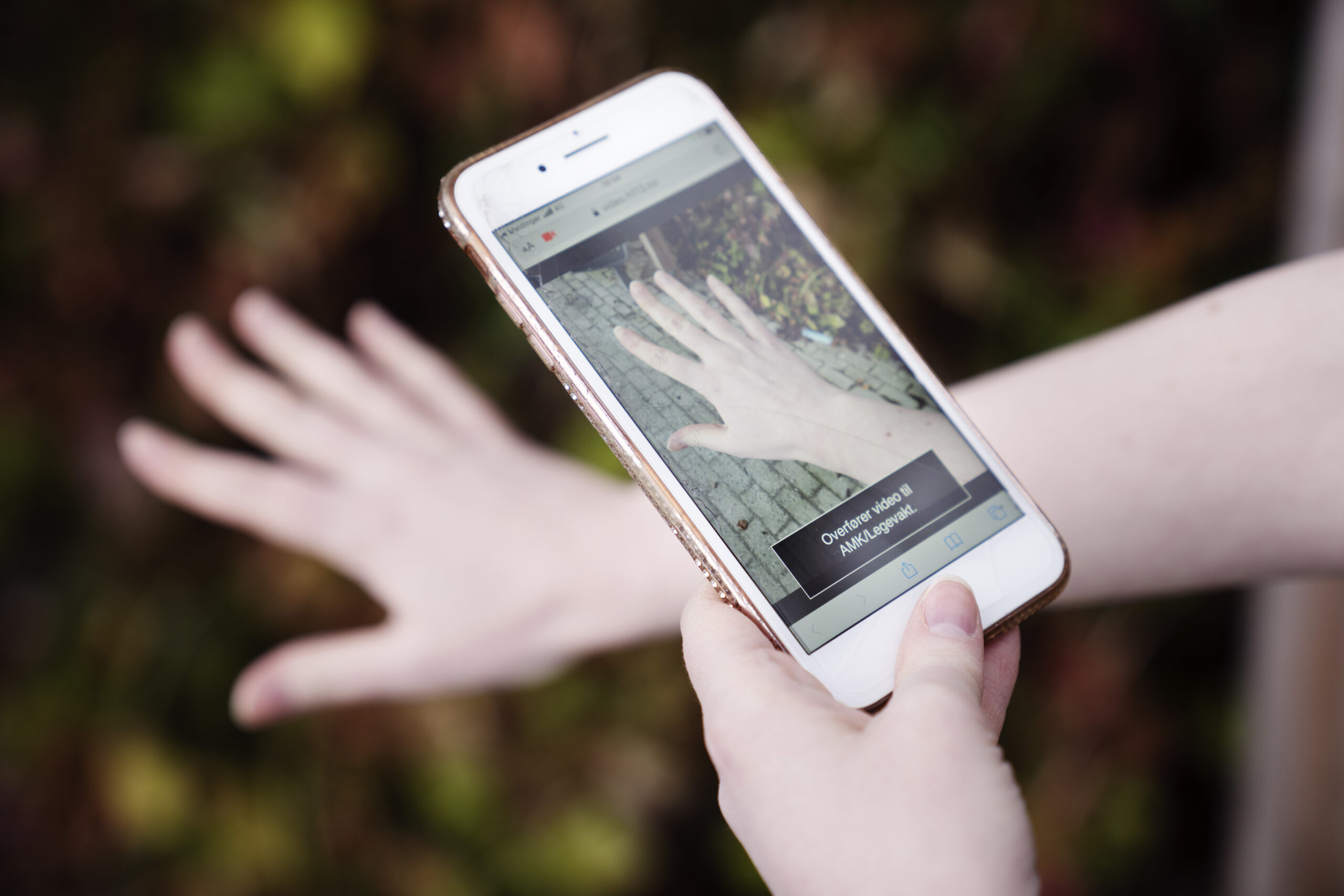 En person filmer hånden sin med mobilen