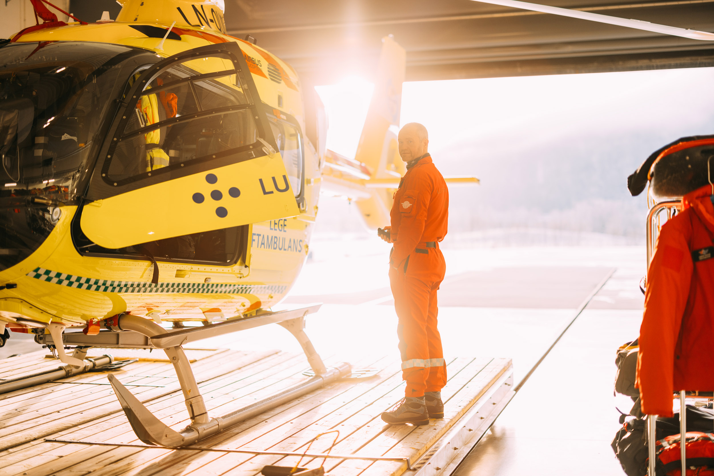 Gult helikopter i motlys, på vei ut fra hangaren ved Førde-basen. Redningsmann Anders Kroken