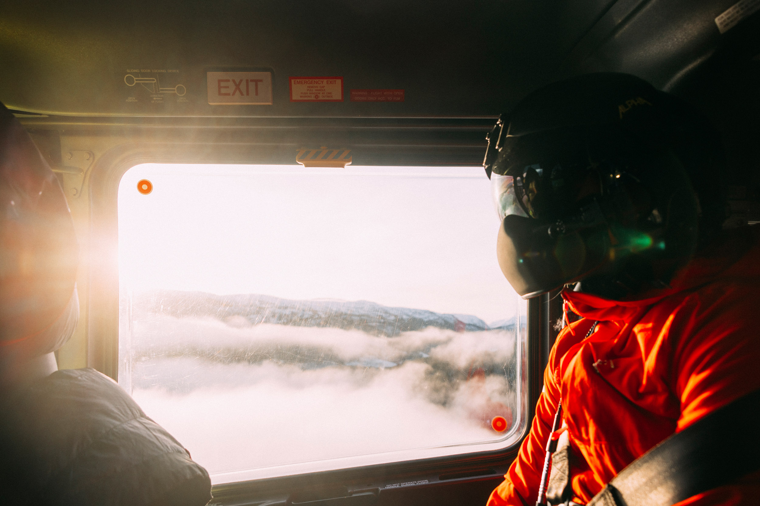 Lavt skydekke utenfor vinduet i helikopteret. Lege Ingrid Nordahl med hjelm