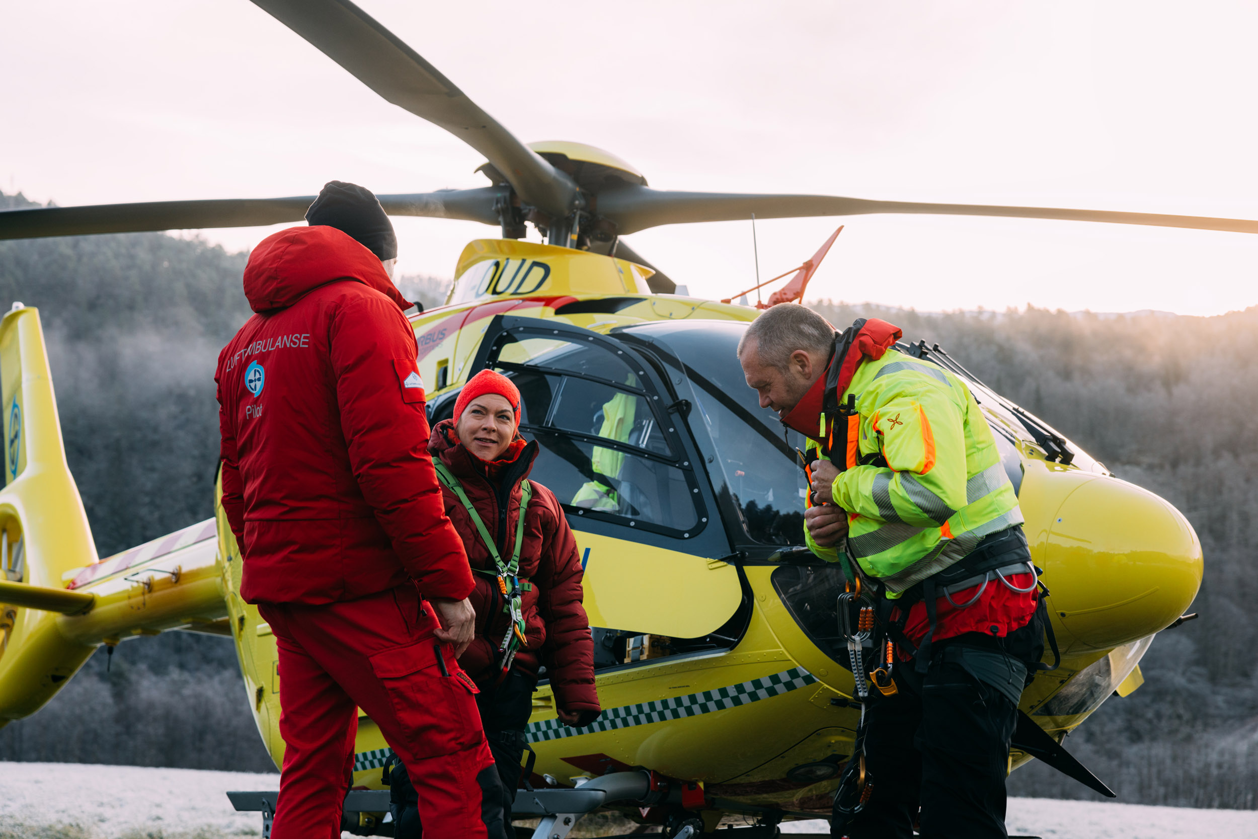 Crew utenfor gult helikopter. Pilot Kjell Ove Frøyset, lege Ingrid Nordahl og redningsmann Anders Kroken