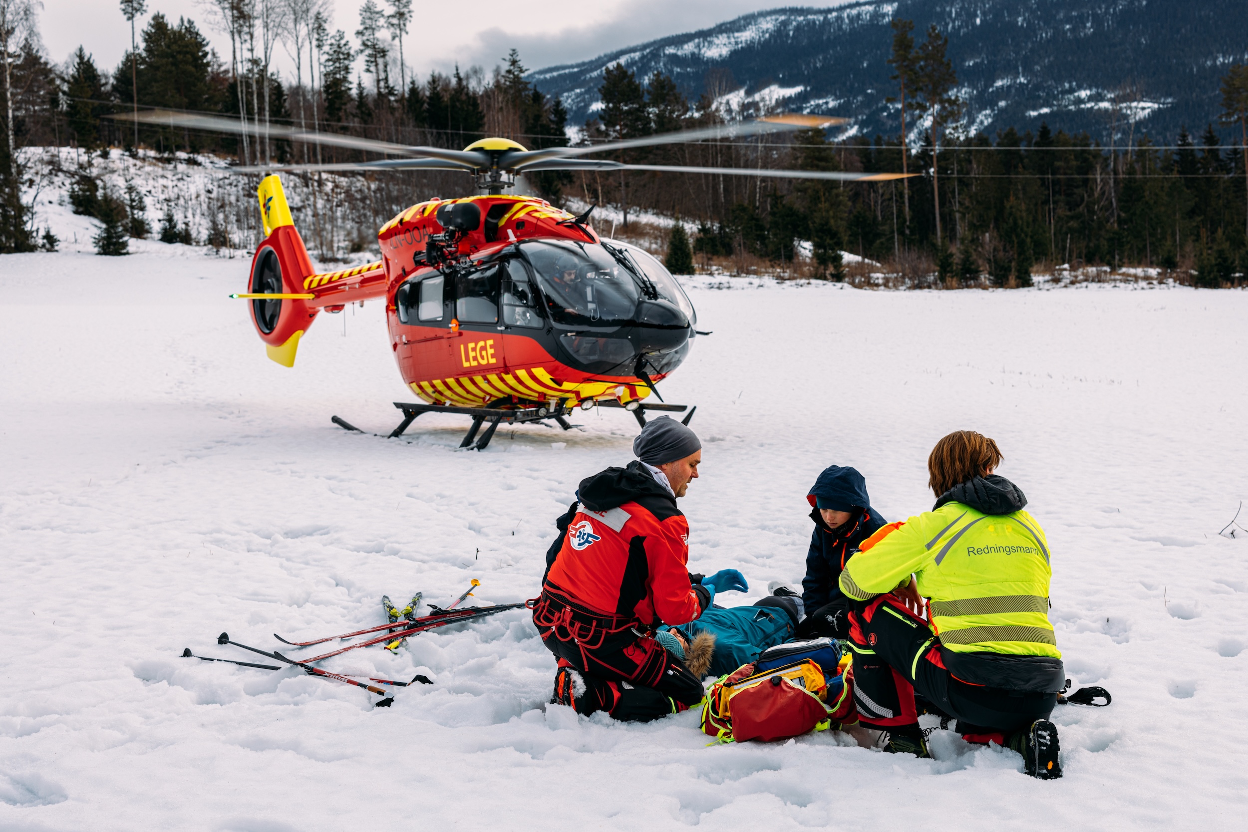 Luftambulansecrew hjelper en pasient som har falt om.