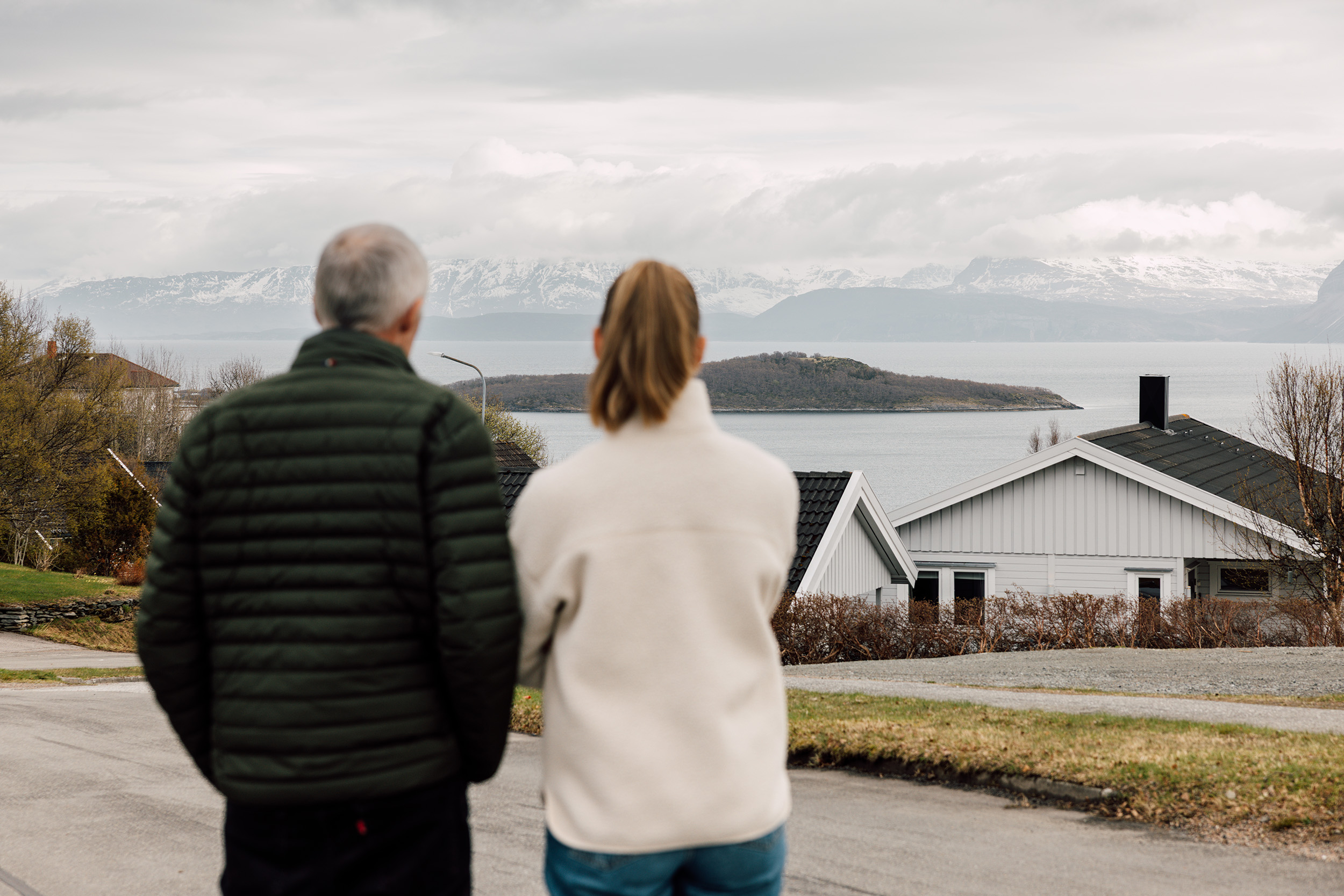 Far og datter skuer ut på Arnøya, utenfor Harstad. I dette sundet drev båten rundt mens Karina kjempet for å gjenopplive Thor. Til høyre i bildet ser du huset til Karina og familien.