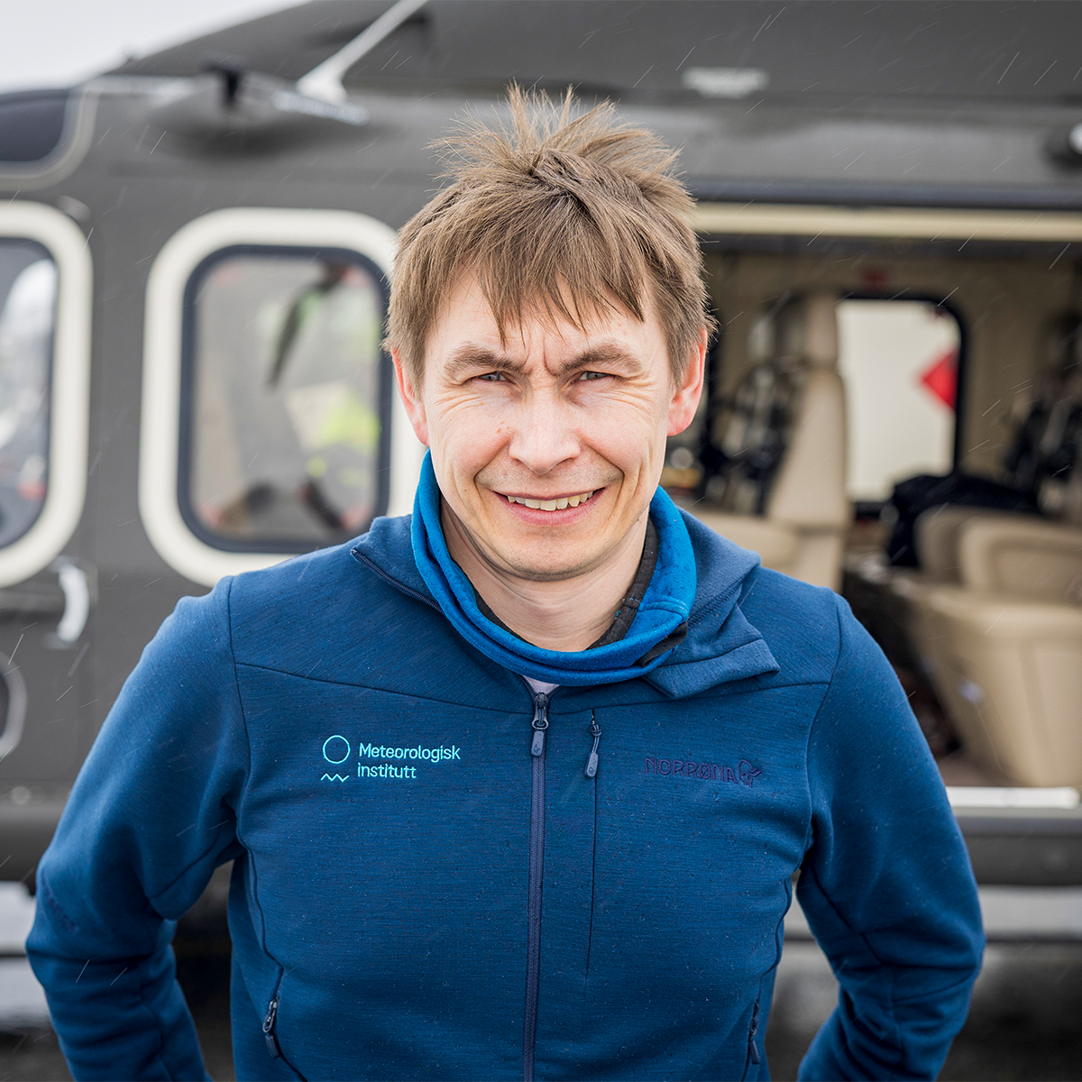 Portrett av Eirik Mikal Samuelsen foran helikopter