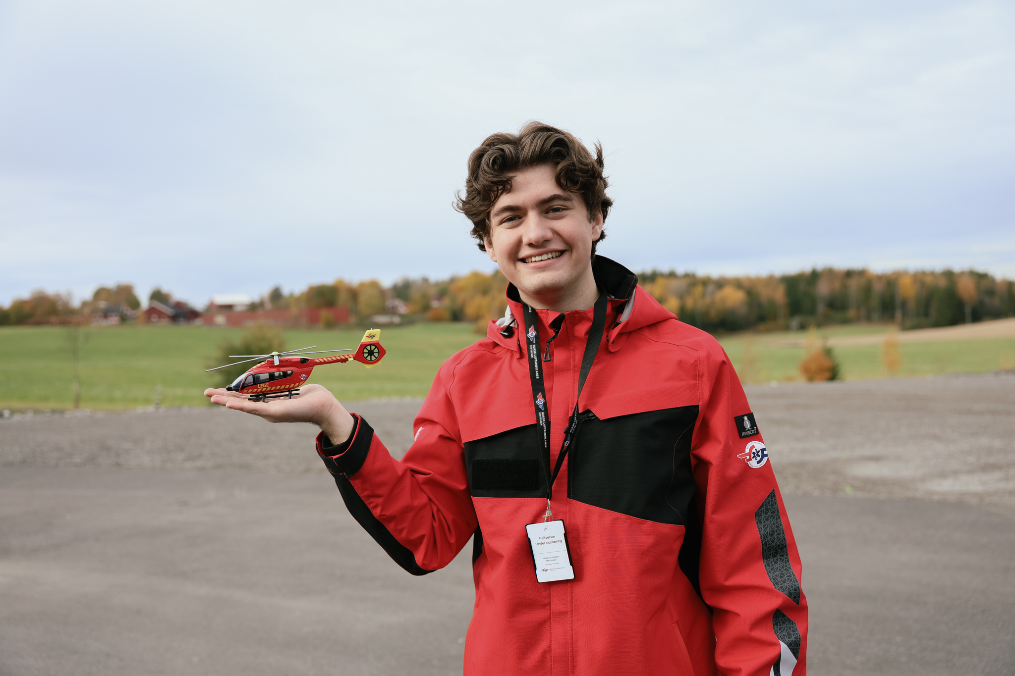 Håkon holder et modellhelikopter og smiler til kamera.