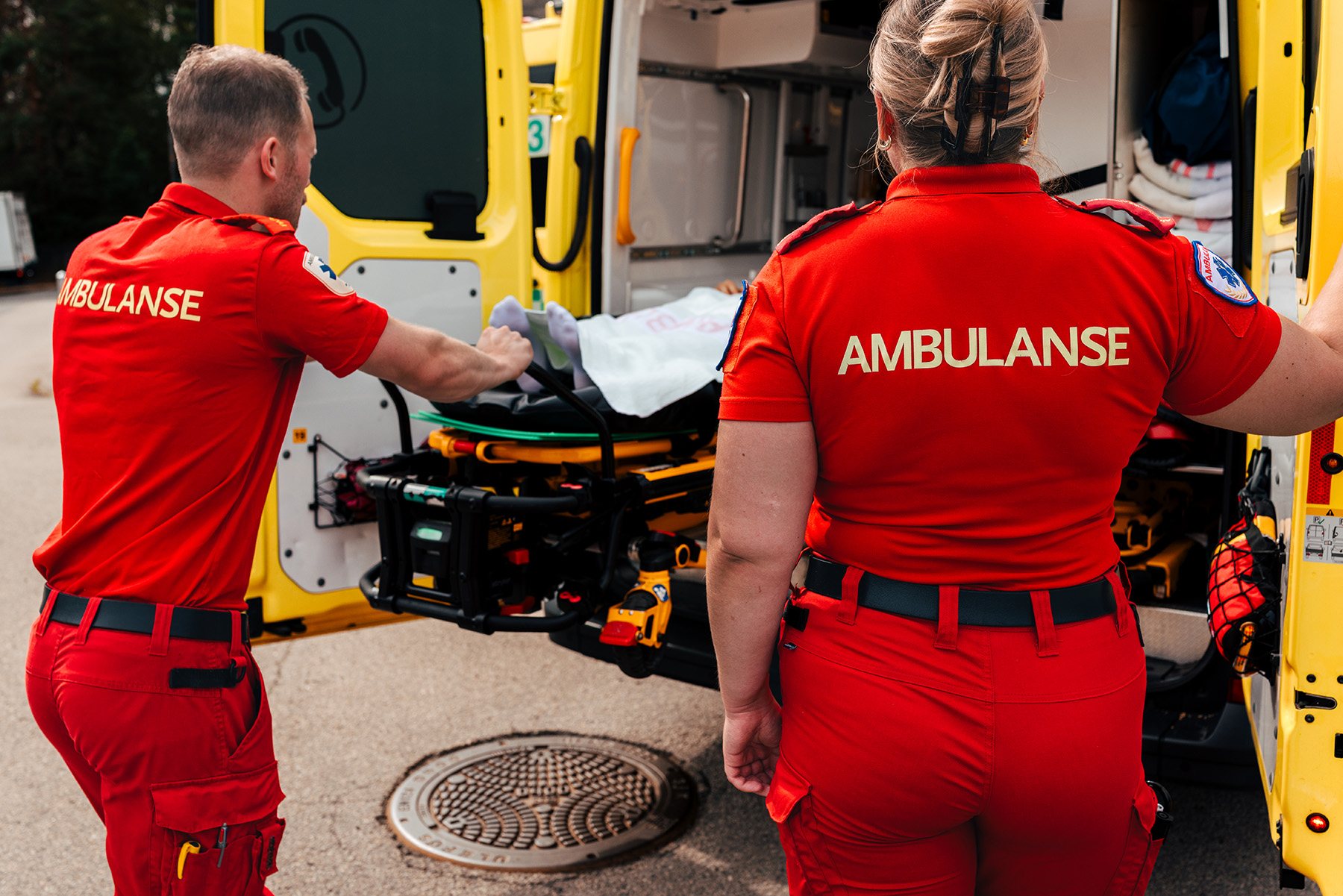 Ambulansepersonell laster person inn i ambulanse