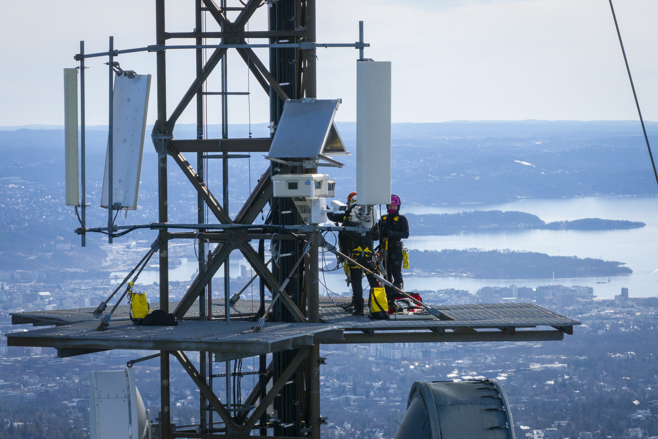 Teknikkere monterer værkamera i masten på Tryvann i Oslo
