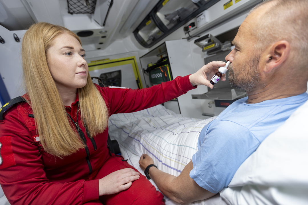 Patient receiving pain relief via nasal spray in an ambulance 