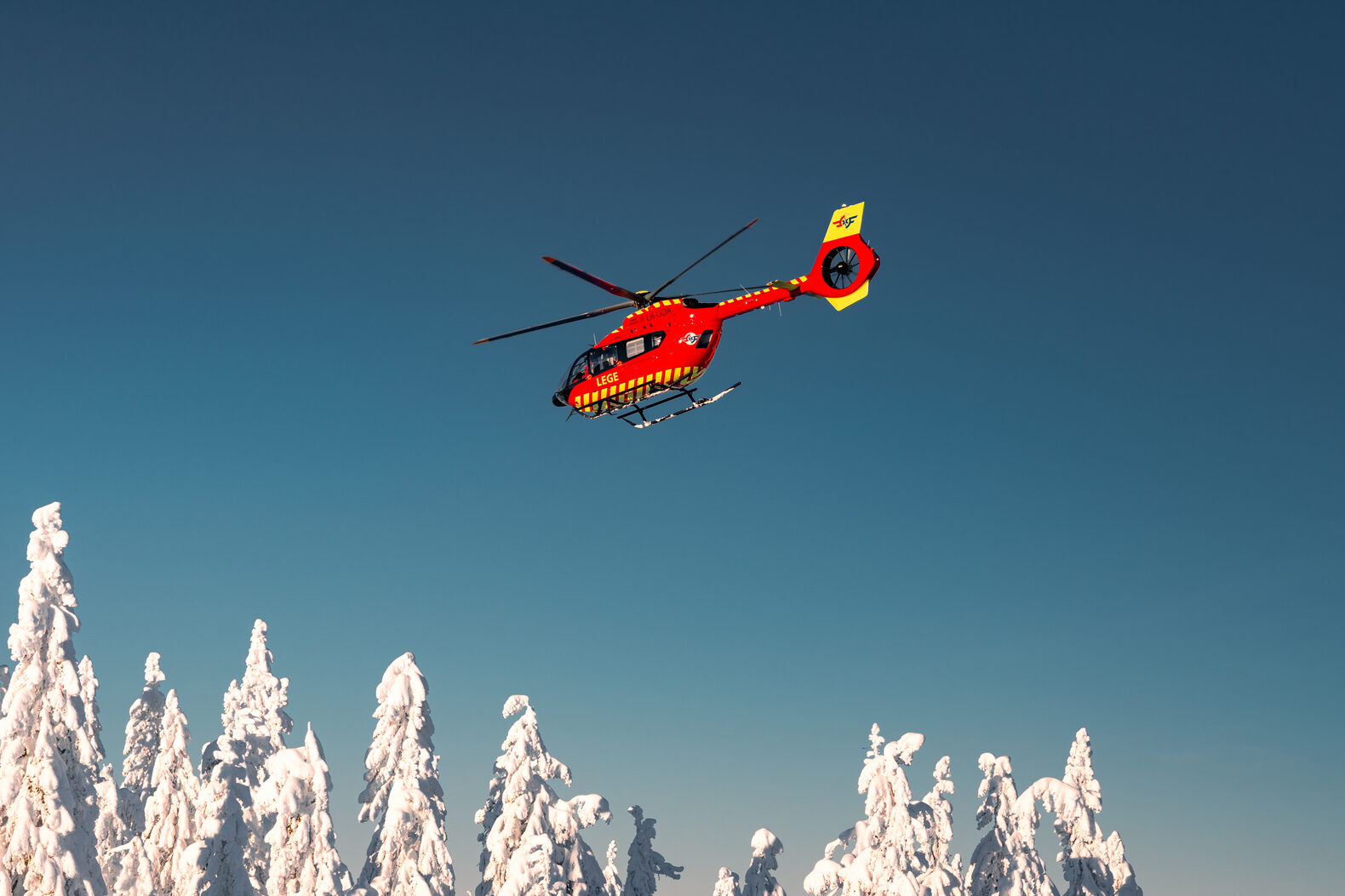 Rødt helikopter i snølandskap