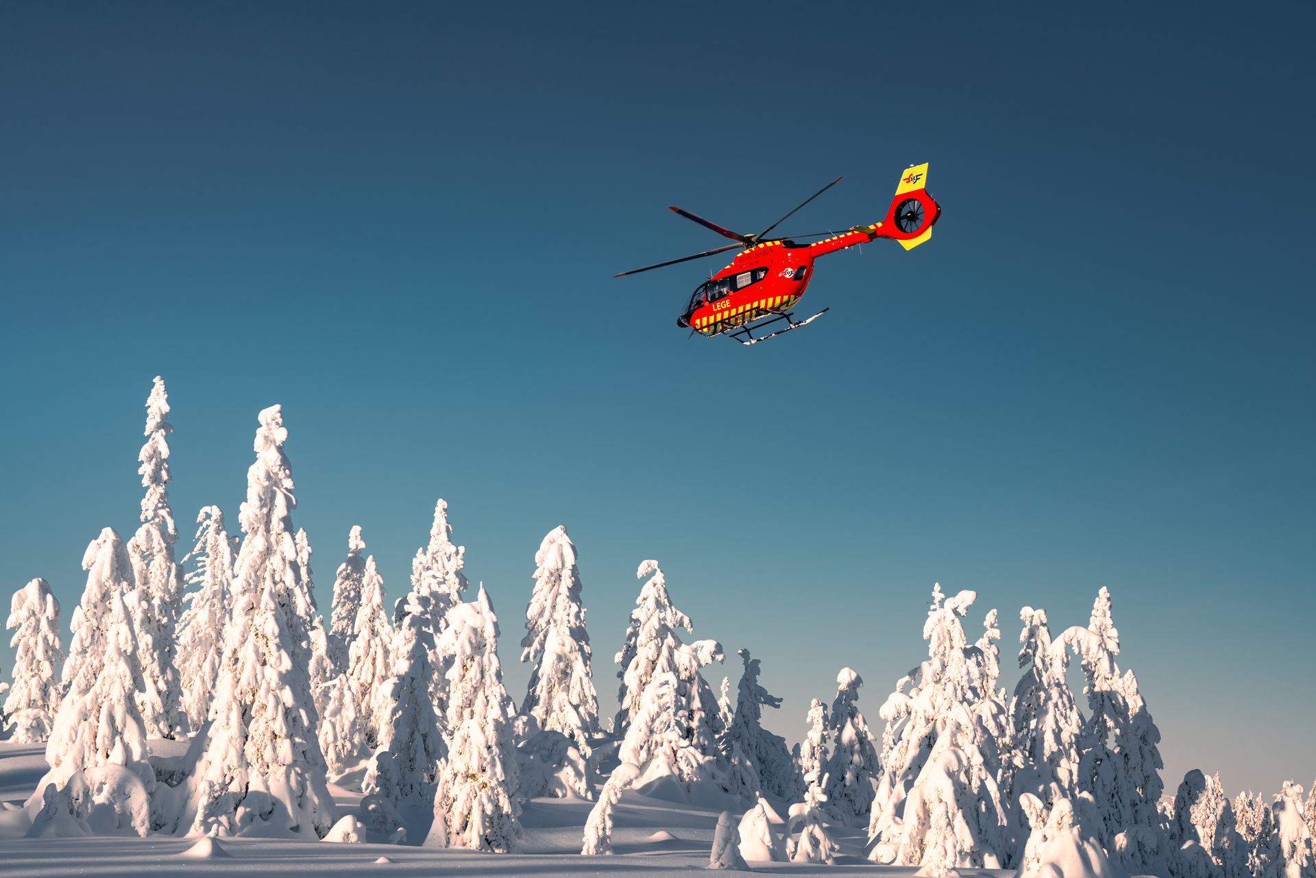 Rødt helikopter i vinterlandskap