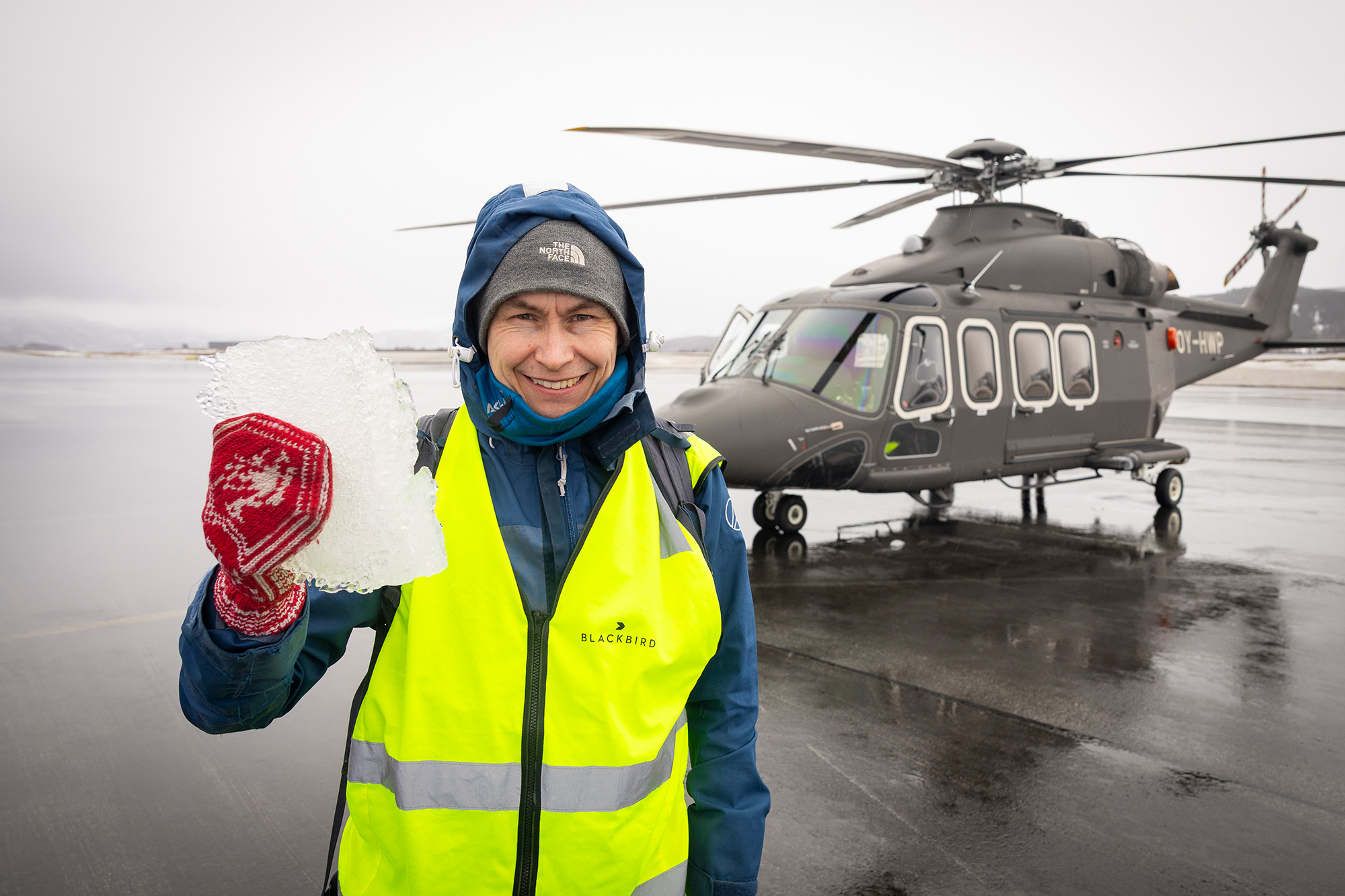 Statsmeteorolog og forsker Eirik Mikal Samuelsen holder en stor klump med is fra helikopteret