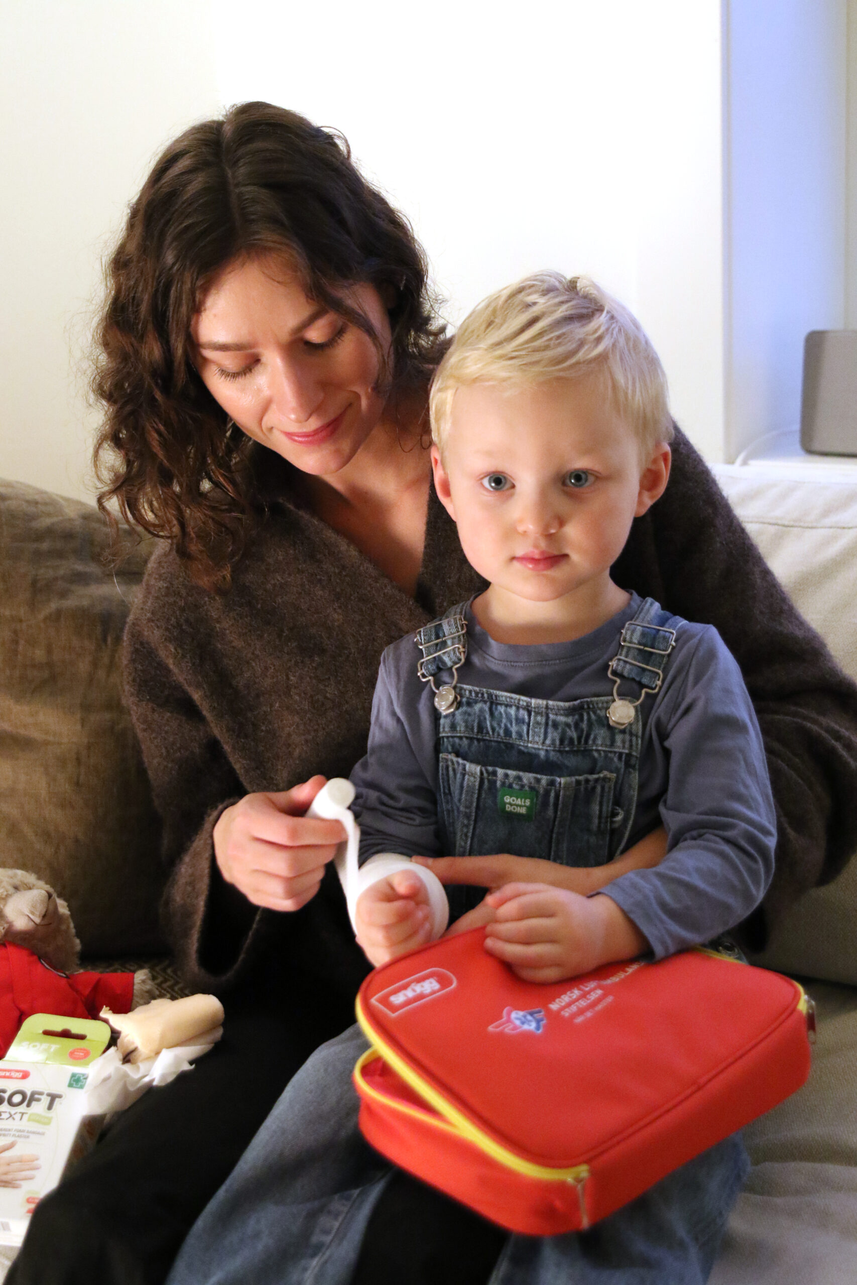 Mor og sønn viser frem førstehjelpspakken.