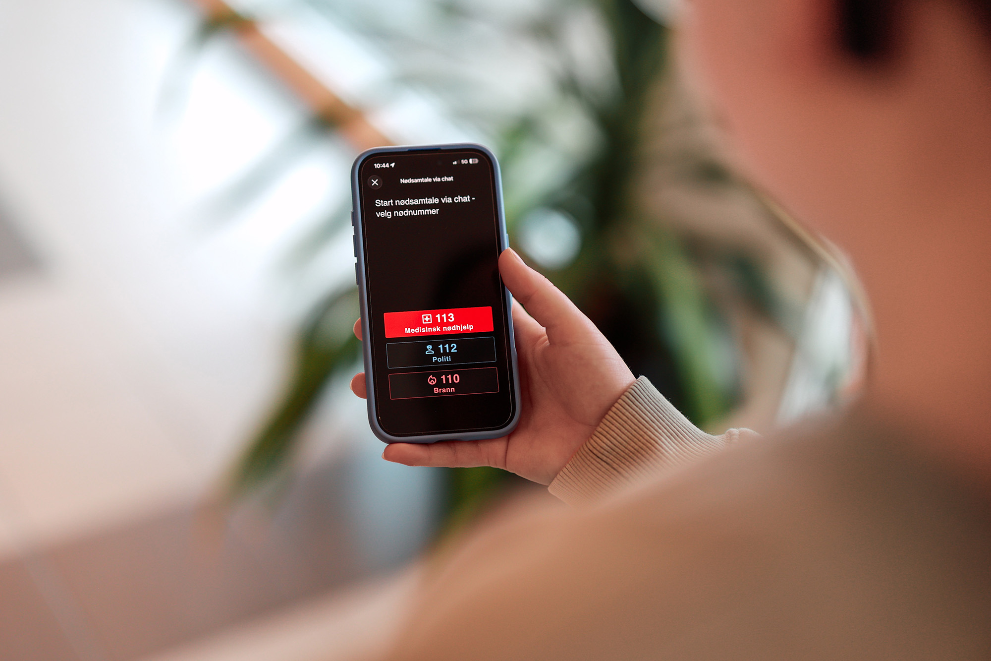 Person ser på mobil med nødchat