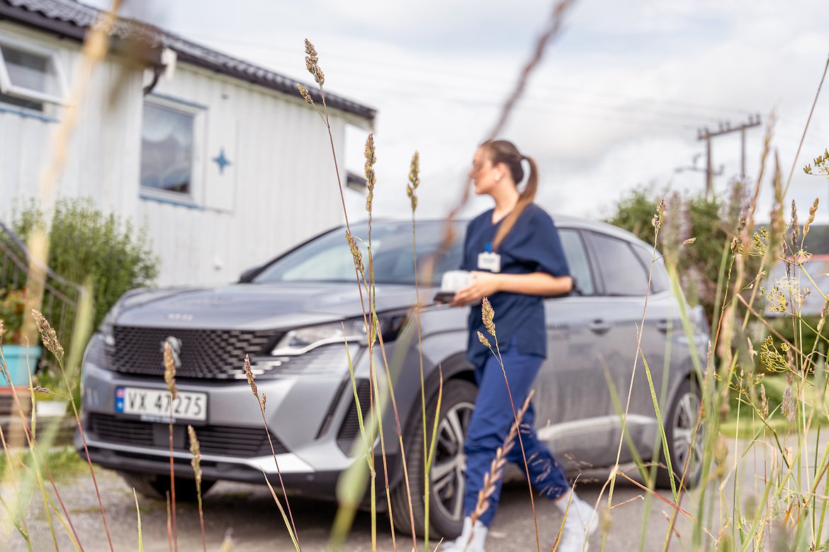 Dame fra hjemmetjenesten går fra bilen