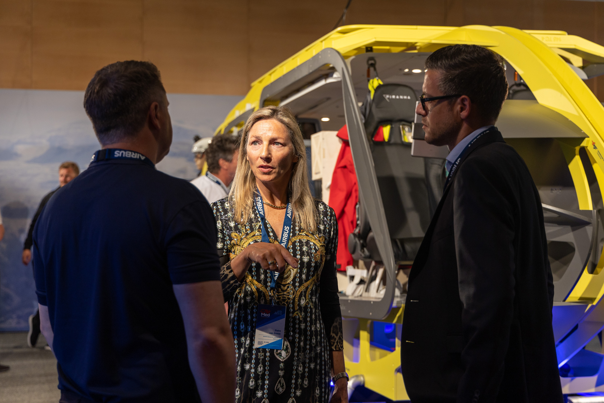 People discussing the conference stand of the Norwegian Air Ambulance Foundation at AirMed 2022.